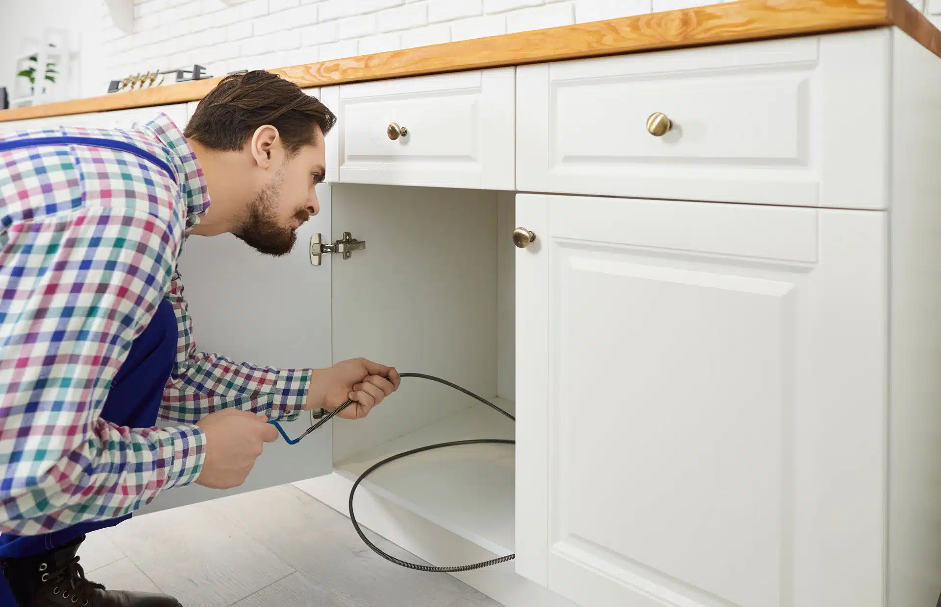 Plumber clearing a clogged pipe